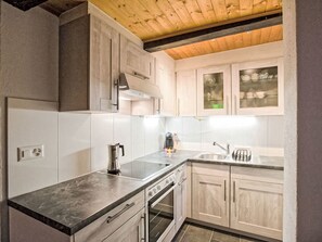 A modern kitchen with a built-in oven, a coffee maker, and a sink.