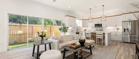 A modern kitchen with white cabinets, a stainless steel refrigerator, and a microwave.