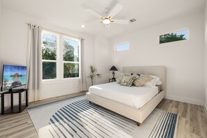 A bedroom with a bed, a ceiling fan, a window, a painting, and a small table with a lamp. - Clean, new built spacious house, downtown, close to everything (Houston)