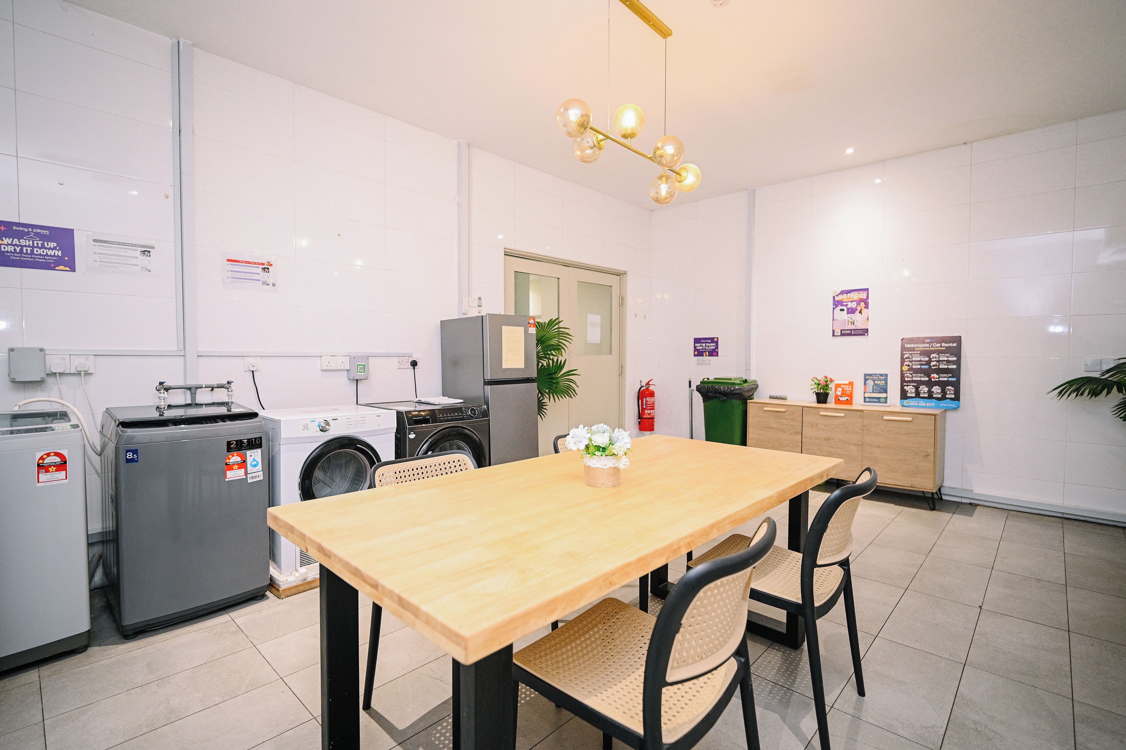 Una cocina limpia y moderna con una mesa de madera, sillas y una lavadora.