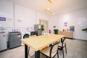Una cocina limpia y moderna con una mesa de madera, sillas y una lavadora.