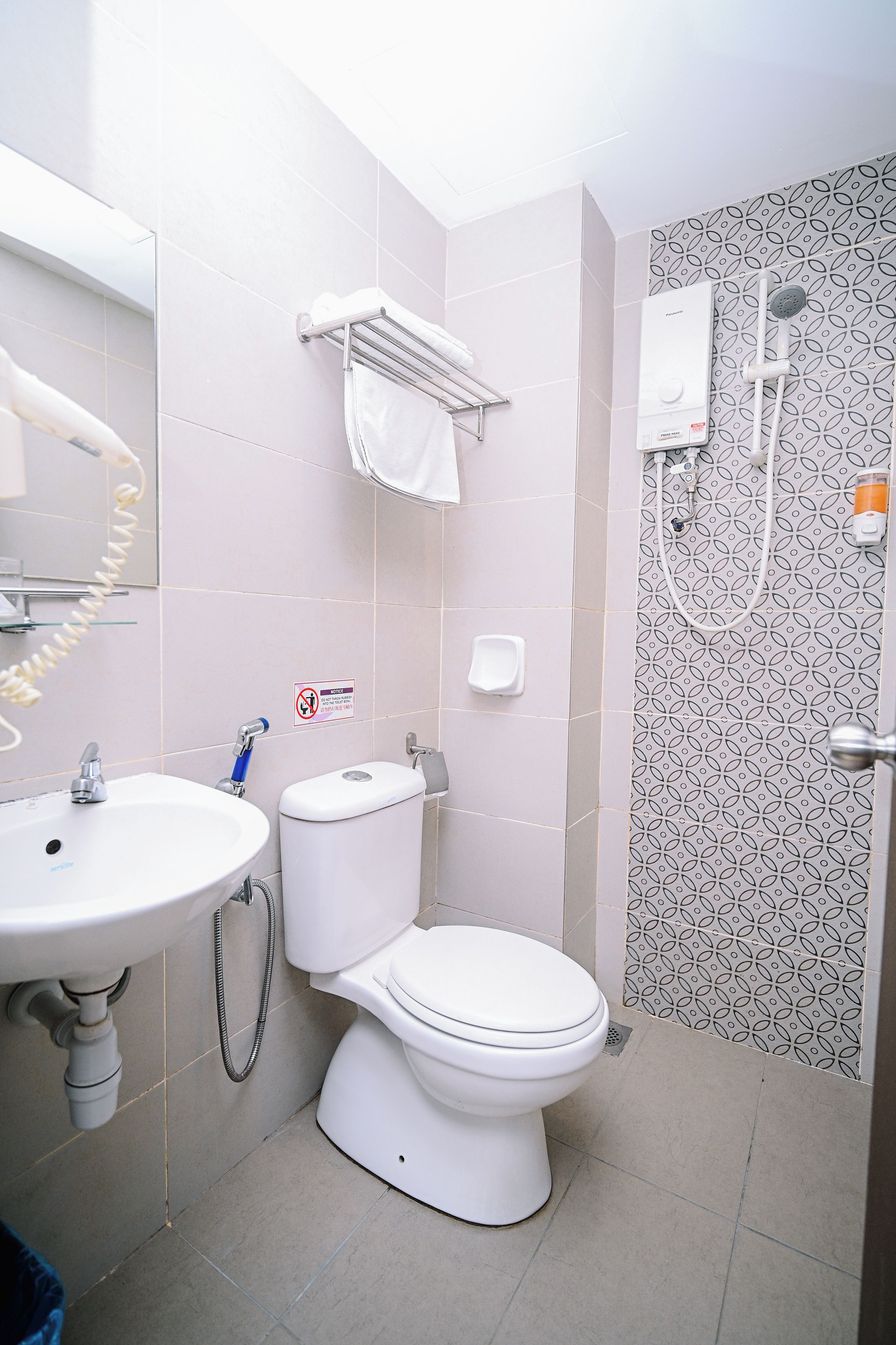 A bathroom with a toilet, sink, and shower.