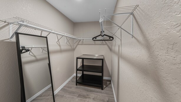 Quarto compacto com estante embutida, cabideiro e porta.