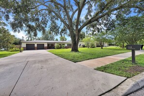 A residential property with a garage, a large tree, and a sign indicating the address. - Casa Solterra | 5 Bedroom Pool Retreat | Temple Terrace | Sleeps 12 (Temple Terrace)