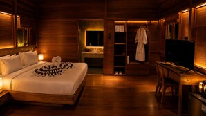 A wooden room with a bed, a desk, and a television. - Krisna Osea Villas  (Buleleng)