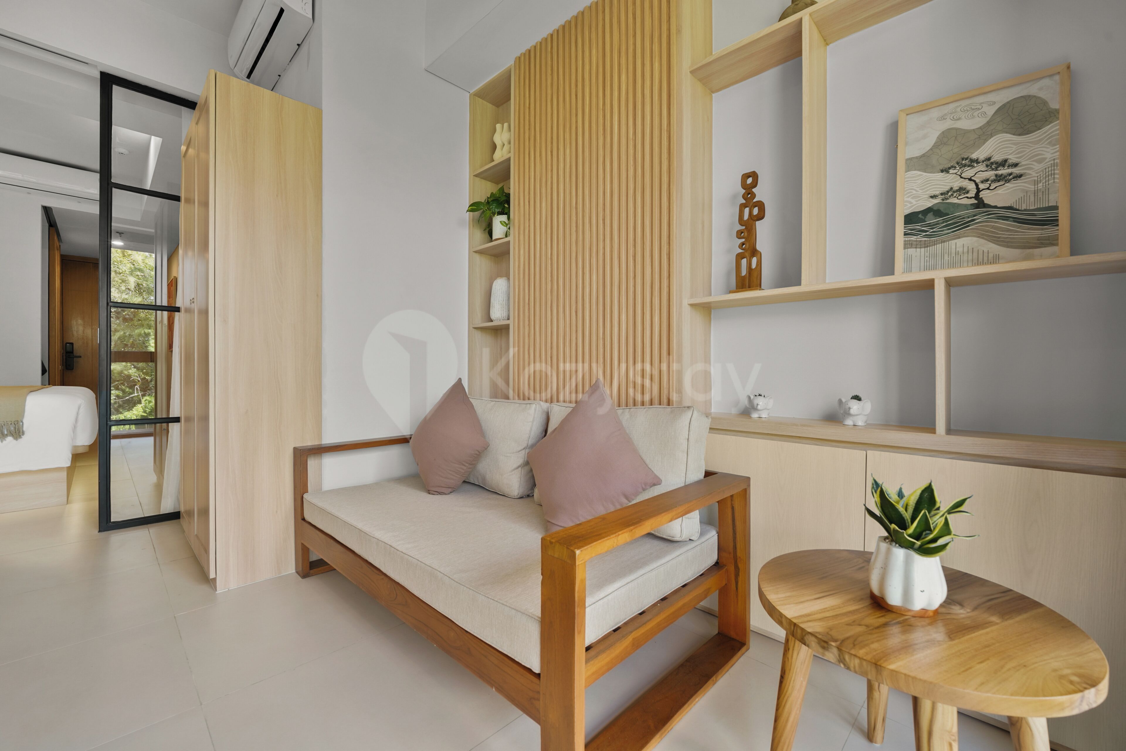 Een moderne woonkamer met een bank, een bijzettafeltje en een potplant.