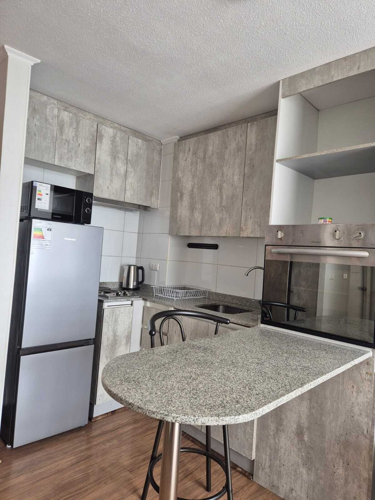 Una cocina equipada con microondas, refrigerador, estufa y horno.