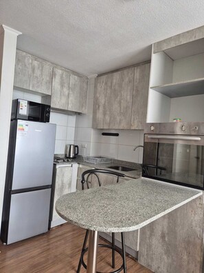 Una cocina equipada con microondas, refrigerador, estufa y horno.