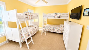 A room with bunk beds, a television, and a dresser. - Ocean Front 6bed/6bath, gourmet kit, heated pool, private beach access (Ocean Isle Beach)