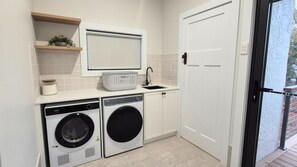 A laundry area with a washing machine, dryer, and a sink. - Newly Renovated 4-Bedroom Retreat in East Tamworth (East Tamworth)