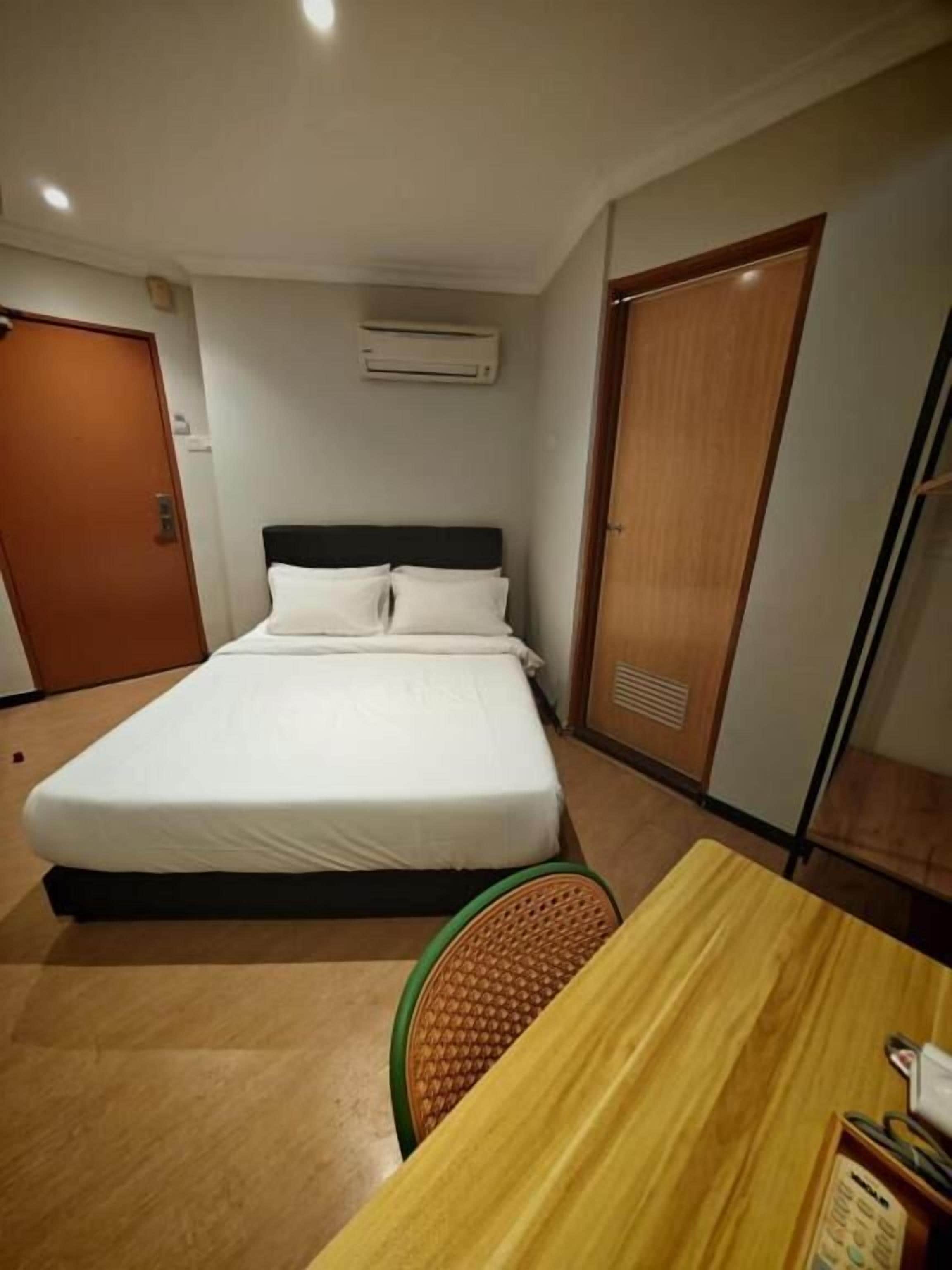Una habitación de hotel con una cama, una mesa de madera y una silla.