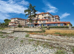 Ett hotell med flera våningar, balkonger, en restaurang och utsikt över stranden.