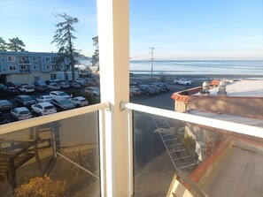 A view from a balcony overlooking a parking lot and a beach.