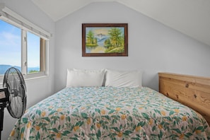 A bedroom with a bed, a window, a fan, and a painting on the wall. - One of the Area’s Highest-Elevation Condos! (GATLINBURG)