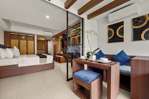 A modern living room with a sofa, a coffee table, and a dining area with chairs. - Vantara by Kozystay - Nusa Dua (Badung)