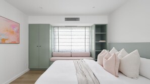 A bedroom with a bed, a window with a seat, a wardrobe, and a bookshelf. - Ornos 3 Bedroom Apartment in Fingal Bay (Fingal Bay)