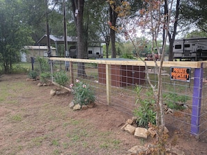 Ein von einer Ziegelmauer umgebenes Grundstück mit einer Holztür, einer Überwachungskamera und einem Schild mit der Aufschrift 'PRIVATE PROPERTY NO TRESPASSING'.