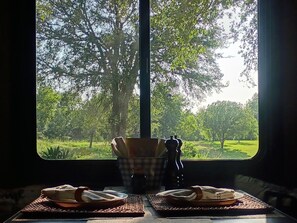 A table with a view of a park through a window. - Peaceful rv get away on the river (Smithville)