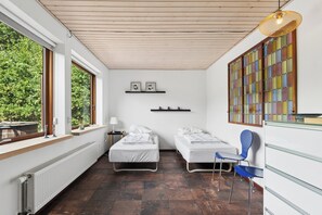 A room with two beds, a chair, a radiator, and a window with a view of greenery. - Holiday home with billiards, shelter & fire pit (Silkeborg)