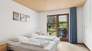 A bedroom with two beds, a window with a view of greenery, and a wooden ceiling. - Holiday home with billiards, shelter & fire pit (Silkeborg)