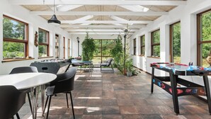 A spacious indoor area with a foosball table, seating, and large windows. - Holiday home with billiards, shelter & fire pit (Silkeborg)
