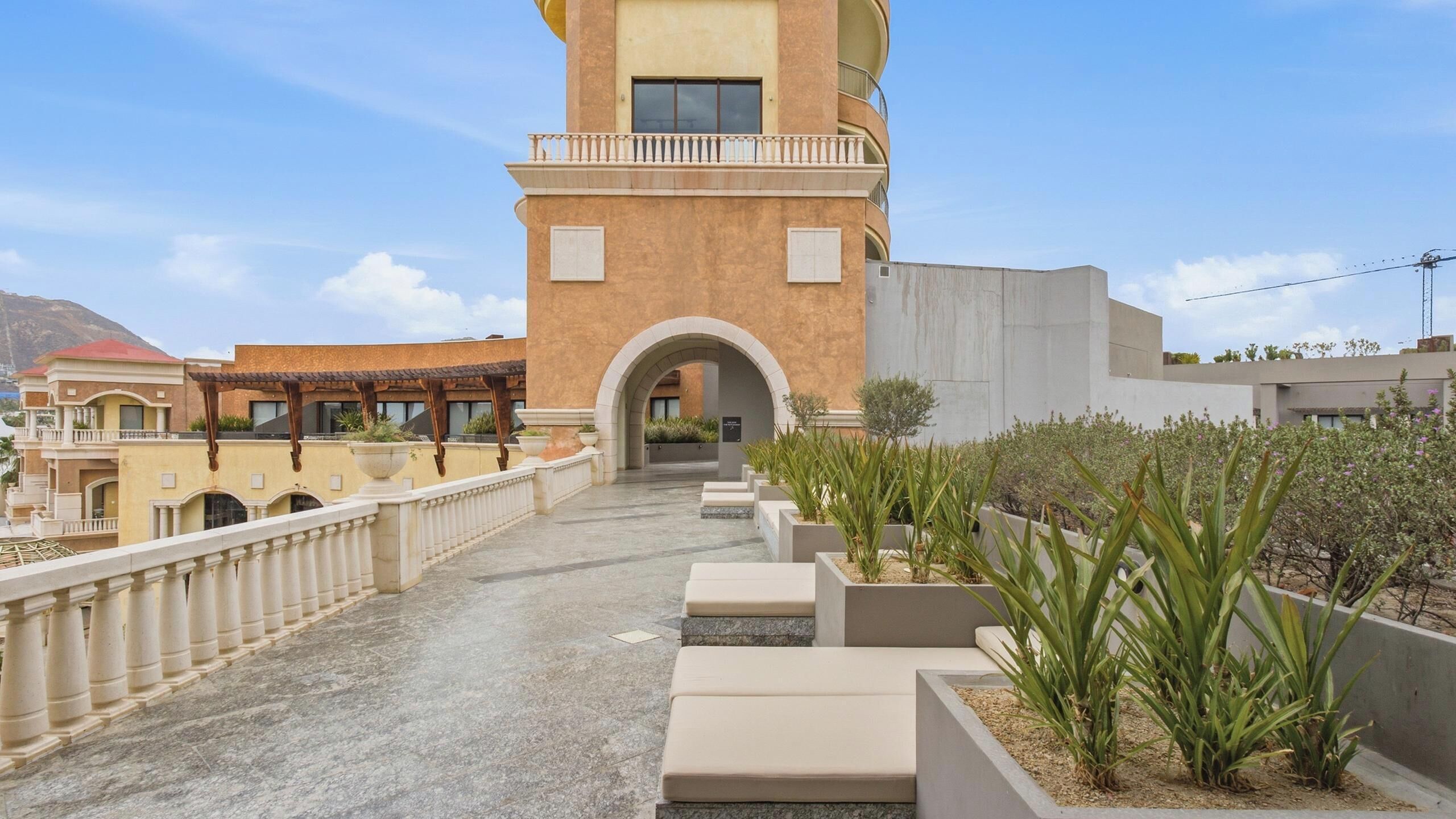 A hotel with a central courtyard, a covered outdoor seating area, and a view of the mountains.