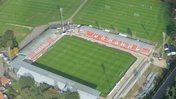 Et stort stadion med flere fodboldbaner og tilskuerpladser.