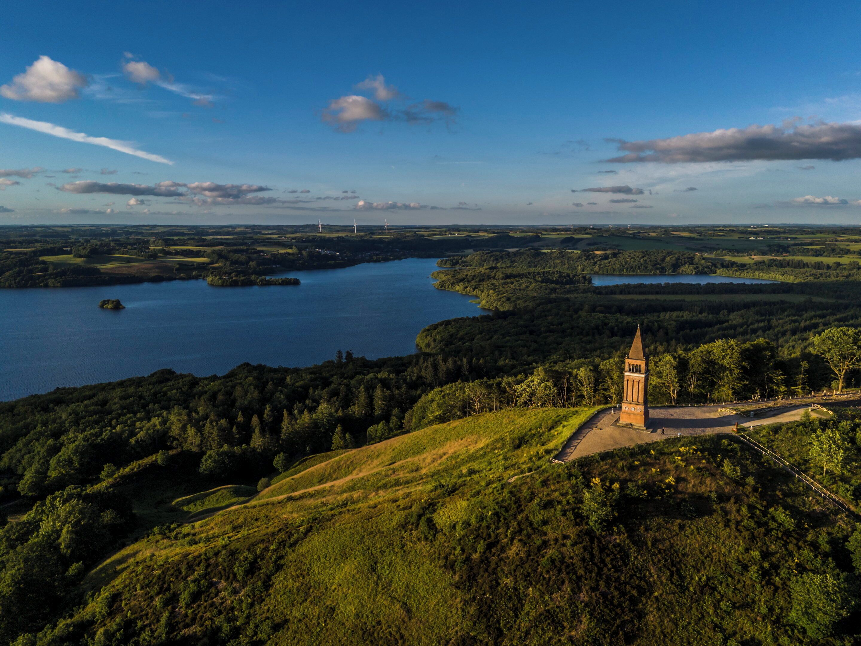 Kukkulalla kohoava torni, josta avautuu näkymä järvelle ja sen ympäröivään metsään.