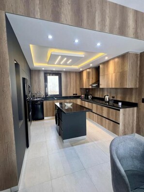 Una cocina moderna con una isla central, armarios de madera e iluminación empotrada en el techo.