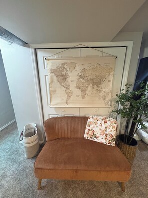A room with a brown sofa, a world map on the wall, a potted plant, and a trash can. - Spacious 4-bedroom, 5 bed, Family House with AC in perfect Missoula location (Missoula)