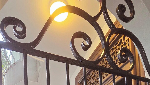 A gated entrance with a decorative metal gate, a white railing, and a wooden door. - Luxury 3BR Apartment Nugegoda bordering Colombo 5 (Nugegoda)
