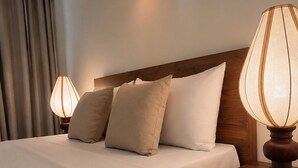 A hotel room with a neatly made bed, two bedside lamps, a wooden nightstand, and a wall-mounted light fixture. - Luxury 3BR Apartment Nugegoda bordering Colombo 5 (Nugegoda)