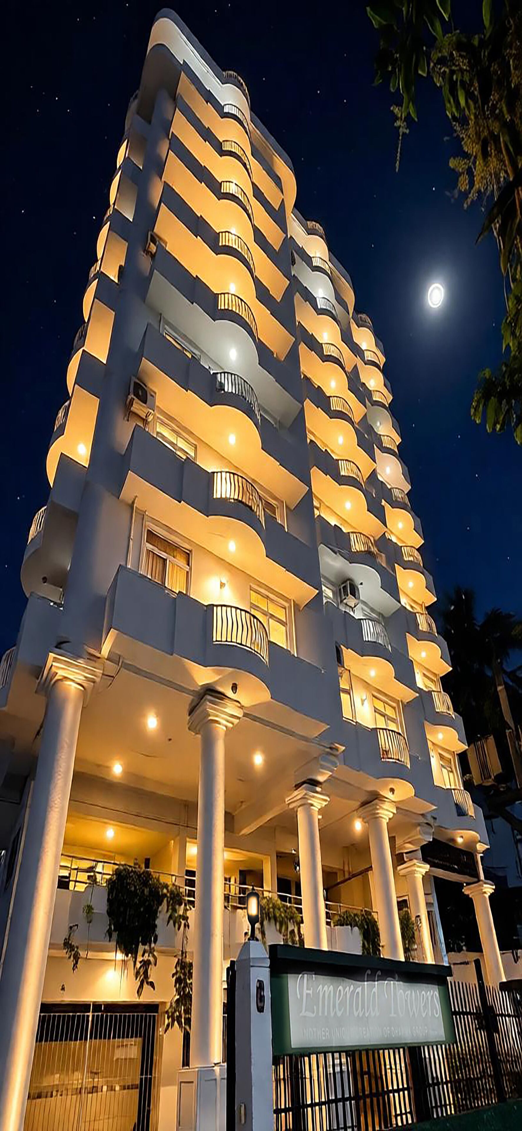 Ein mehrstöckiges Hotel mit modernem Design, mit Balkonen auf jeder Etage und einem markanten Eingang mit einem Schild.