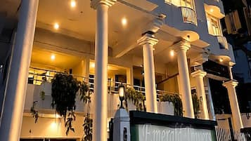 Un hotel de diverses plantes amb disseny modern, que destaca per balcons a cada planta i una entrada ben visible amb un rètol.