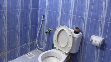 Une salle de bain avec des toilettes, un bidet et une fenêtre.