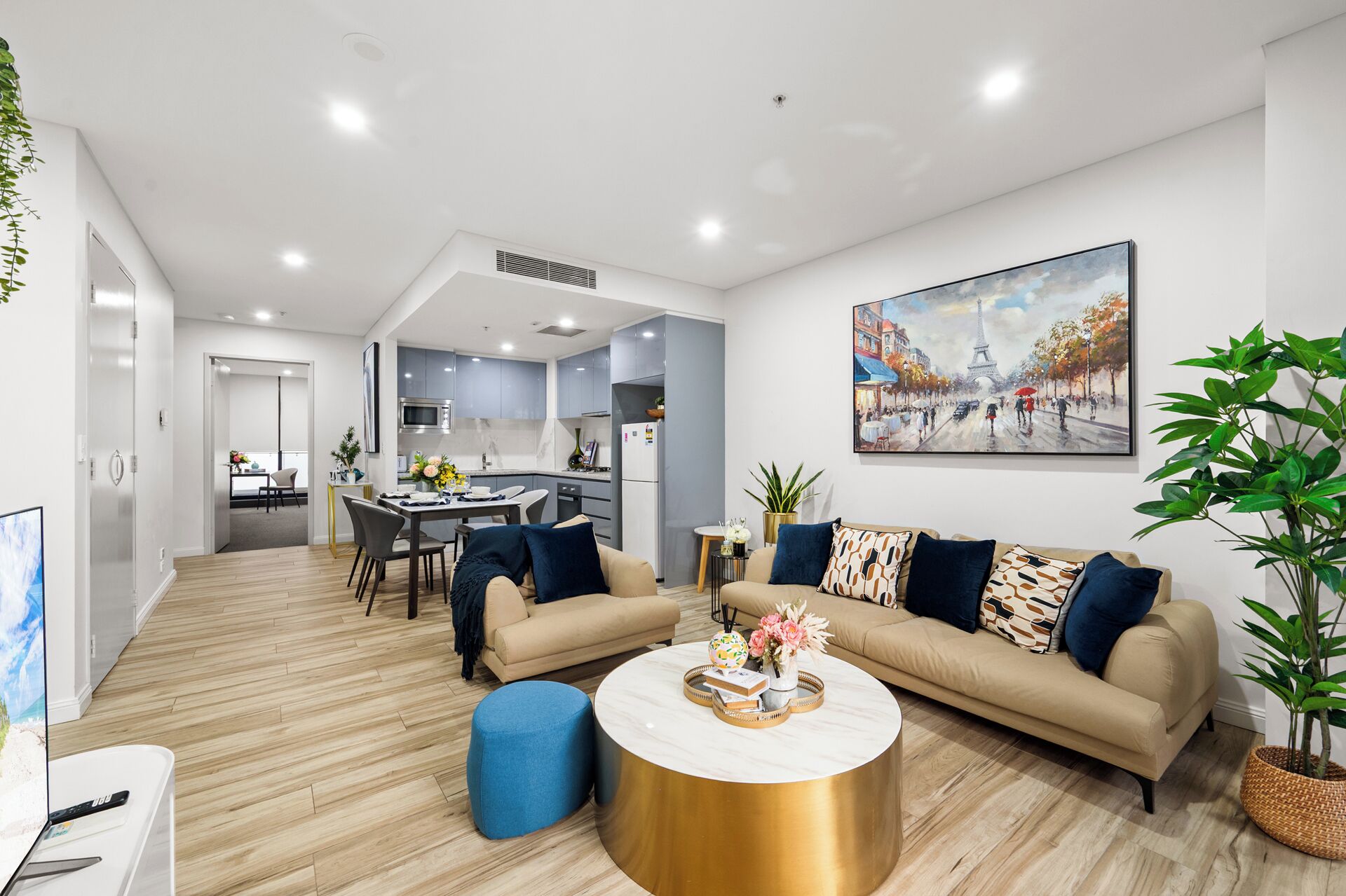 A modern living room with a sofa set, a coffee table, and a dining area with chairs.