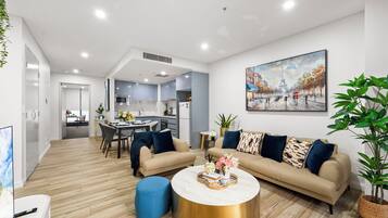 A modern living room with a sofa set, a coffee table, and a dining area with chairs.
