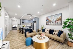 A modern living room with a sofa set, a coffee table, and a dining area with chairs.