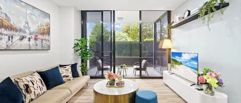 A modern living room with a sofa, coffee table, and a TV.