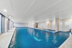 An indoor swimming pool with clear water, tiled walls, and a tiled floor. - Robbie Williams Stay | Walk to Accor Stadium | Sydney Olympic Park (Sydney Olympic Park)