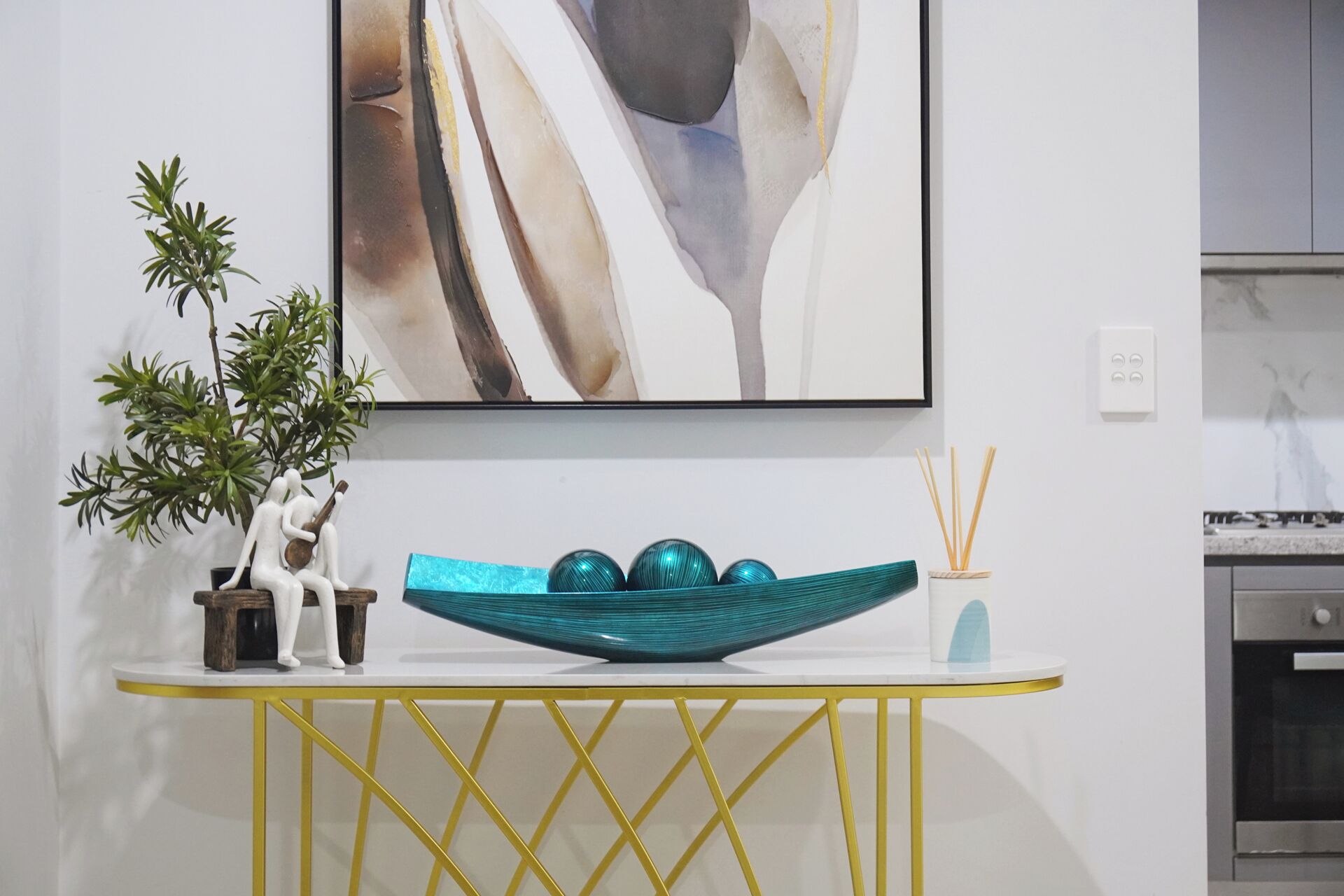 A modern kitchen with a white countertop, a decorative bowl, and a potted plant.