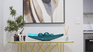 A modern kitchen with a white countertop, a decorative bowl, and a potted plant.
