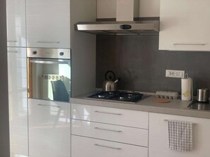 A modern kitchen with a built-in oven, a gas stove, and a kettle. - A smart and efficient apartment, perfect for couples or business stays near Siena. (Sovicille)
