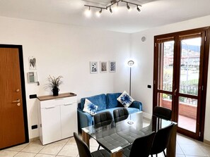 Ein stilvolles Wohnzimmer mit Essbereich, einer Couch und Blick durch eine Glastür.