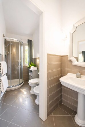 Ein modernes Badezimmer mit Glasdusche, Toilette und Waschbecken.