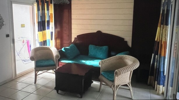 A living room with a sofa, two armchairs, a coffee table, and a hanging light fixture. - Ti Case Sainte Anne, Martinique (Sainte-Anne)