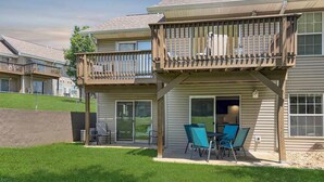 A residential building with a balcony, sliding glass doors, and outdoor seating. - No stairs, clean peaceful secluded, close to strip (Branson)