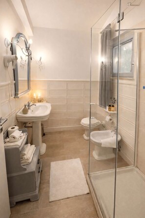 Ein modernes Badezimmer mit einer Glaskabine zur Dusche, einem Standwaschbecken und einer Toilette.