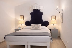Ein Hotelzimmer mit einem großen Bett, zwei Nachttischen mit Lampen und einem dekorativen Kopfteil.