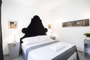 Ein Hotelzimmer mit einem Bett, zwei Nachttischen und einem Wandbild.